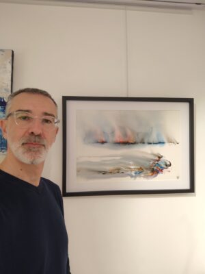Portrait de Christophe Baudin posant devant une toile de la série Aquapictura, inspirée par l’eau et la lumière